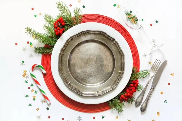 Ajuste de mesa de Navidad con vajilla vintage, platería y decoraciones rojas sobre fondo blanco. Vista superior . — Foto de Stock
