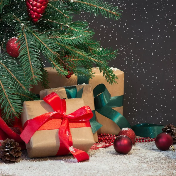Noël fond de vacances. Cadeaux, casquette et décor du Père Noël sous un sapin de Noël sur une planche de bois. Espace de copie sur tableau . — Photo