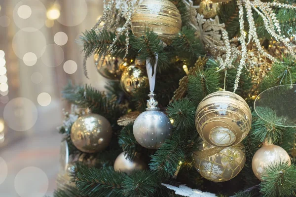 Julgran med gyllene bollar och lampor med kopia utrymme på suddig bokeh bakgrund i gallerian. Närbild. — Stockfoto