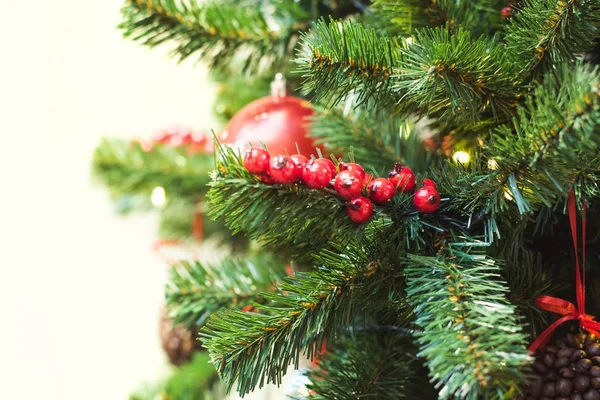 Holly bogyók és a tobozok dekorációval és másol hely homályos bokeh háttér Mall fények, karácsonyfa. Közelről. — Stock Fotó