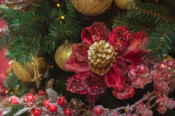 モールぼやけてボケ背景にコピー スペースを装飾として赤のデザイン花とヒイラギの果実のクリスマス ツリー。クローズ アップ. — ストック写真