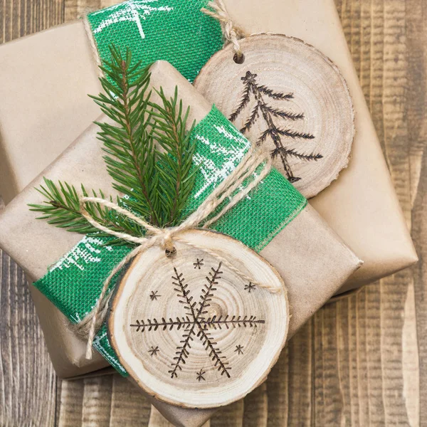 Coffret cadeau de Noël dans un style rustique enveloppé dans du papier avec décor de bois tranché avec symbole de combustion du bois . — Photo