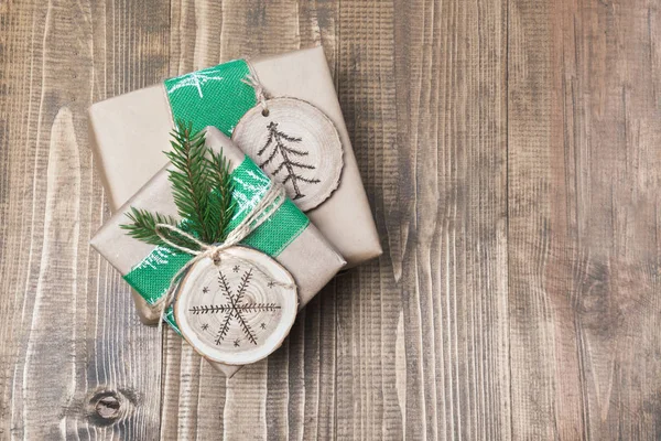 Caja de regalo de Navidad en estilo rústico envuelta en papel con decoración de madera cortada en rodajas con símbolo de leña . — Foto de Stock