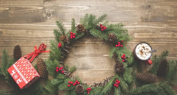 Karácsonyi összetétele Virág Koszorú, díszdobozok, fából készült táblán a piros dekorációval. Lapos feküdt. Felülnézet. Másolja a hely. — Stock Fotó