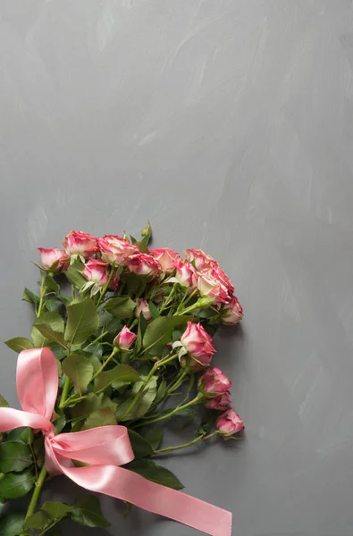 Ramo de rosas rosadas con lazo rosa sobre fondo gris. Vista superior. Copiar espacio . — Foto de Stock