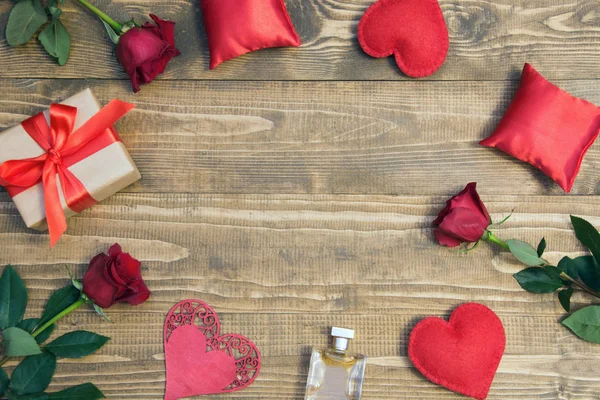 Fondo del día de San Valentín con regalo de amor, rosas rojas, perfumes y formas del corazón. Vista desde arriba. Copiar espacio . — Foto de Stock