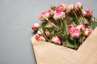 Üstten Görünüm noktası nötr gri arka plan üzerinde pembe Güllü açılan zanaat zarf. Festival kavramı. Sevgililer günü kartı.