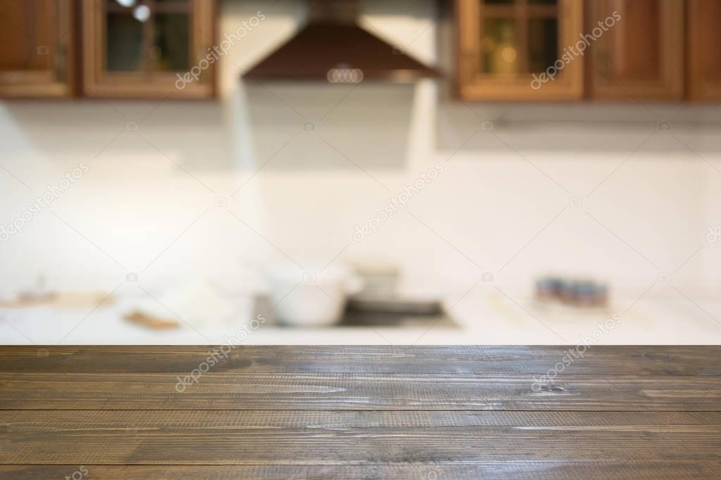 Blurred background. Empty wooden tabletop and defocused modern kitchen for display or montage your products.