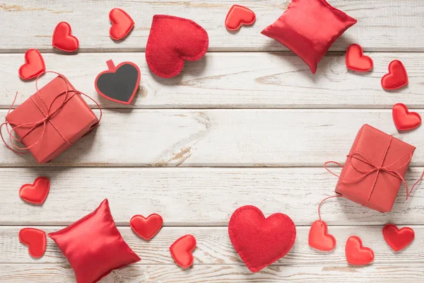 Tarjeta de San Valentín. Decoración roja, corazones, regalos en tabla de madera blanca y espacio para el texto. Vista superior . —  Fotos de Stock