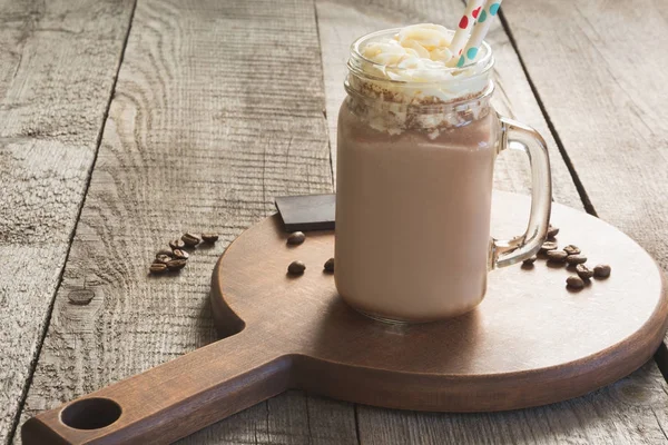 Chocolate batido de café con crema batida servido en tarro de vidrio albañil sobre fondo de madera vintage. Bebida dulce . — Foto de Stock