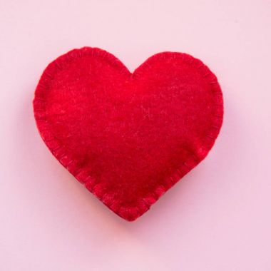 Sevgililer günü kartı. Kırmızı beyaz arka plan üzerinde kalp keçe. Üstten Görünüm.