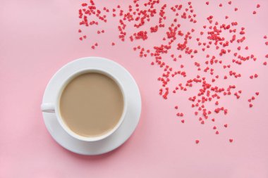 Sevgililer günü kartı. Kahvaltı. Bir fincan kahve süt ve pembe bir arka plan üzerinde şekerlemeler. Üstten Görünüm. İzole.
