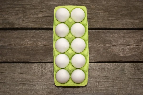 Karton van biologische eieren op houten achtergrond met instant foto. Bovenaanzicht. — Stockfoto