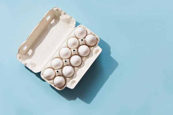 Huevos blancos en el paquete en azul. Vista superior . — Foto de Stock