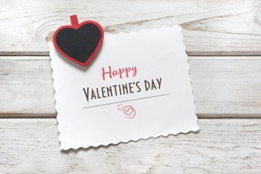 Sevgililer günü kartı. Kırmızı clothespin kalp ve levha ahşap tahta üzerinde dileklerimle. Uzay kopyalayın. Yukarıdan görüntülemek.