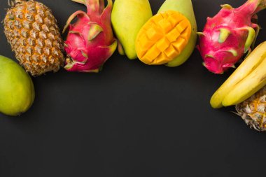 Tropikal meyve ananas, muz, dragon meyve ve mango siyah. Üstten Görünüm.