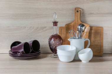 Çanak çömlek, sofra, mutfak eşyaları ve ahşap masa-üstü diğer farklı şeyler. Mutfak tasarımı için arka plan olarak natürmort.