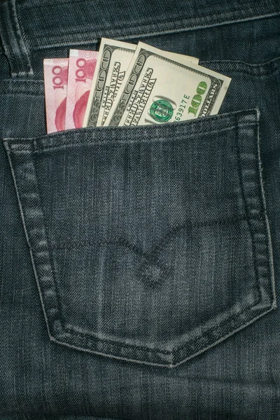 Американський долар і Китаю юанів в кишені у джинси. — стокове фото