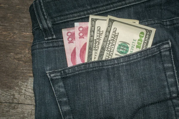 Американський долар і Китаю юанів в кишені у джинси. — стокове фото