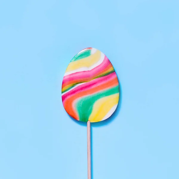 Lollipops dulces como huevo sobre fondo azul. Curioso concepto de Pascua. Vista superior. Imagen cuadrada . — Foto de Stock