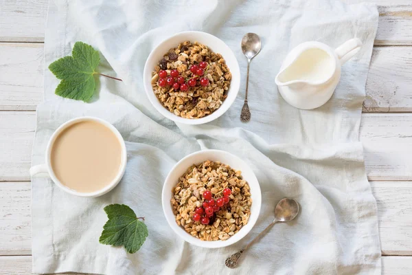 Sommer gesundes Frühstück aus Müsli, Müsli mit Milchkanne und roter Johannisbeere als Dekor. Ansicht von oben. — Stockfoto