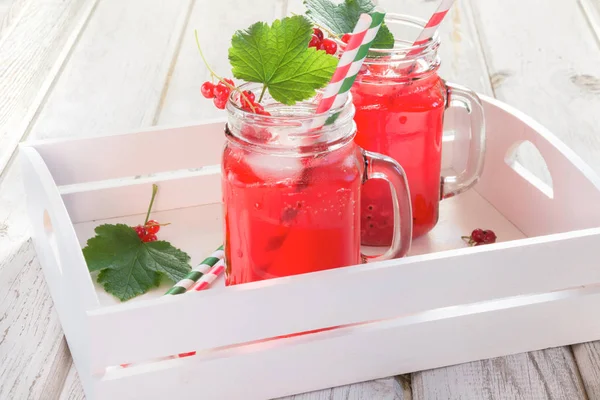 Verano casero limonada de grosella roja en un frasco de albañil con decoración de bayas en bandeja sobre mesa rústica. De cerca. . — Foto de Stock