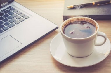 İş Danışma iç dizüstü bilgisayar ve sabah kahve Kupası ile görünümü kapatın. Çalışma Masası bilgisayar ve kahve fincanı tonda fotoğraf.