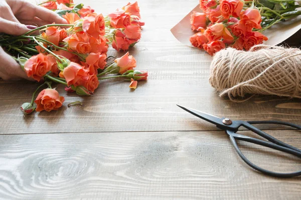 Tavola di lavoro florista.Preparation un mazzo di rose arbusto arancione . — Foto Stock