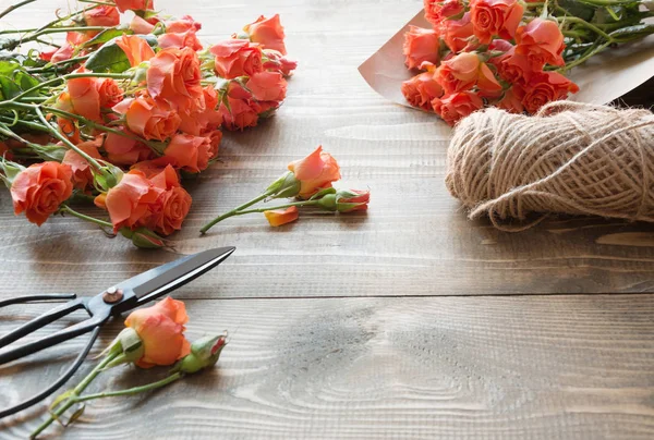 Mesa de trabajo florista.Preparation un ramo de rosas arbusto naranja . — Foto de Stock