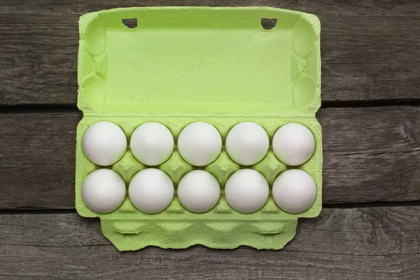 Groene karton van biologische eieren op een houten bord. Bovenaanzicht. — Stockfoto