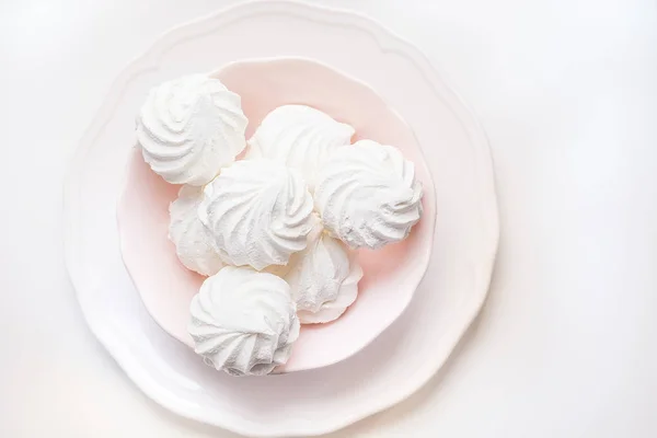 Marshmallows in piatto rosa su un bianco. Vista dall'alto. Focus selettivo . — Foto Stock