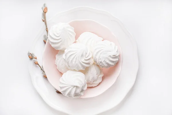 Marshmallows su piatto rosa gentile su un bianco con ramoscello figa-salice . — Foto Stock