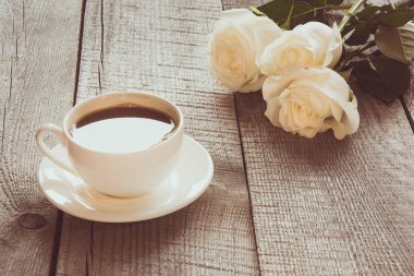 Kopya alanı ile ahşap tahta üzerinde siyah kahve ile yumuşak tam gaz beyaz gül. Tonlu görüntü. Yakın çekim.