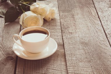 Kopya alanı ile ahşap tahta üzerinde siyah kahve ile yumuşak tam gaz beyaz gül. Tonlu görüntü. Yakın çekim.