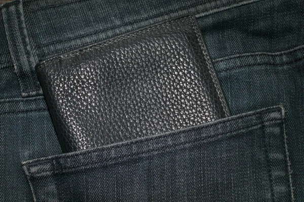 Черный бумажник и синие джинсы . — стоковое фото