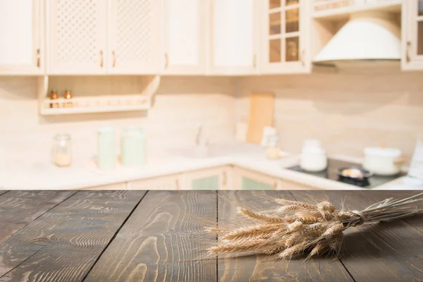 Fundo desfocado. Mesa de madeira com trigo e cozinha moderna desfocada para exibir seus produtos . — Fotografia de Stock