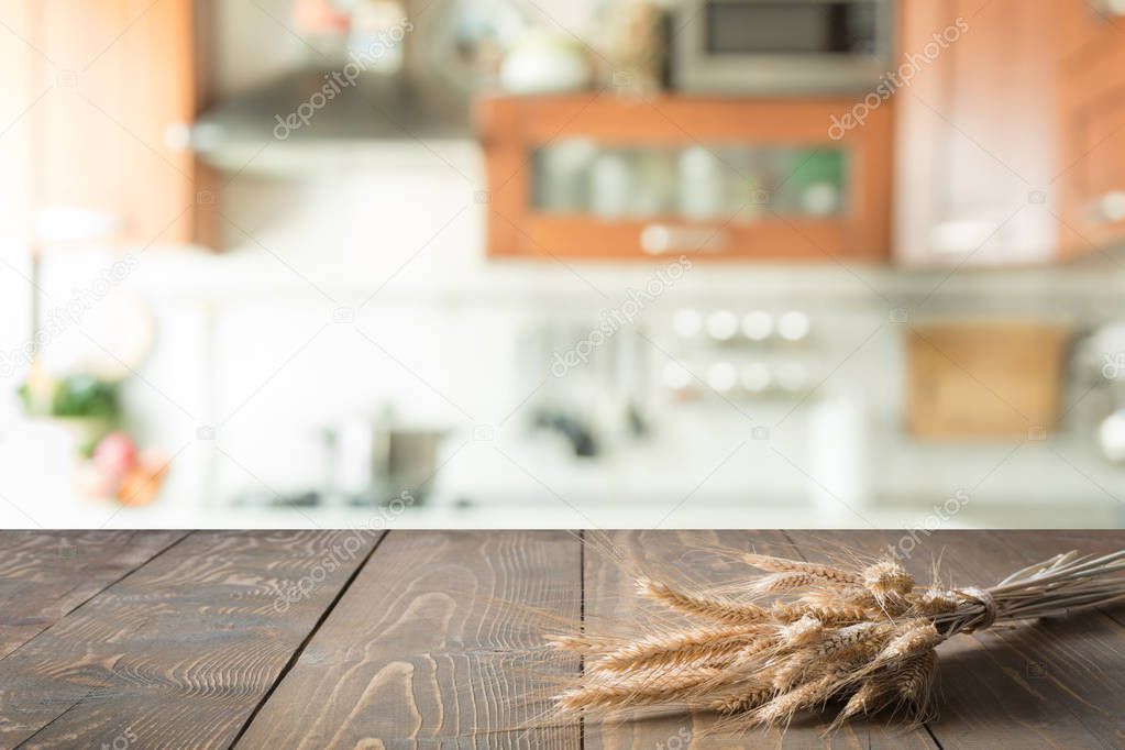 Wooden tabletop with wheat on blur kitchen room background for montage product.