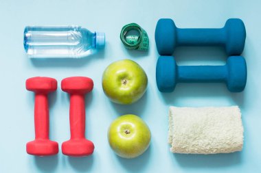 Spor donatımı. Mavi arka plan kopya alanı ile spor ve fitness ekipmanları yaratıcı düz lay.