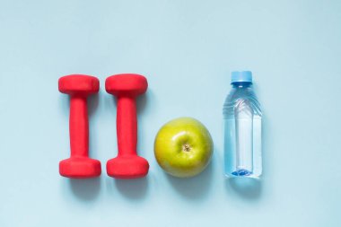 Spor donatımı. Mavi arka plan kopya alanı ile spor ve fitness ekipmanları yaratıcı düz lay.