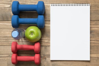 Spor ve fitness ekipmanları, yaratıcı düz gemide yatıyordu. Boş boş alan ile. Üstten Görünüm.