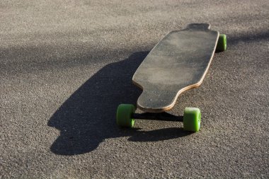 Eski bir boş asfalt yolda izole longboard kullanılan.
