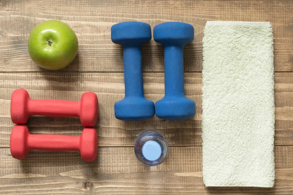 Equipamiento deportivo y de fitness, diseño plano creativo sobre tabla de madera. Espacio para ti . — Foto de Stock