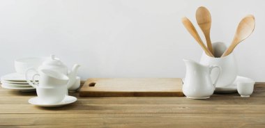Beyaz mutfak gereçleri, dishware ve diğer farklı beyaz şey beyaz ahşap tahta üzerinde hizmet için.