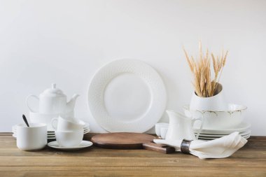 Beyaz mutfak gereçleri, dishware ve diğer farklı beyaz şey beyaz ahşap tahta üzerinde hizmet için.