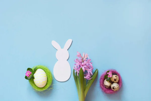 Concepto de Pascua. Conejito blanco y huevos de pollo pintados con decoración de flores en azul. Vista superior. Puesta plana . — Foto de Stock