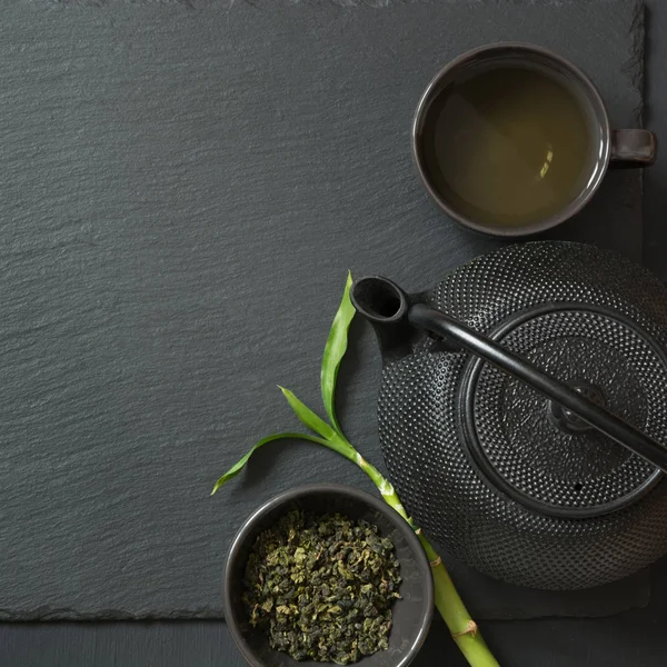 Zöld japán tea a fekete kőasztalon. Felülnézet másolási hellyel. — Stock Fotó