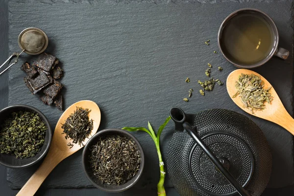 Diferentes tipos de té verde japonés y chino en la mesa de piedra negra. Vista superior con espacio de copia . —  Fotos de Stock