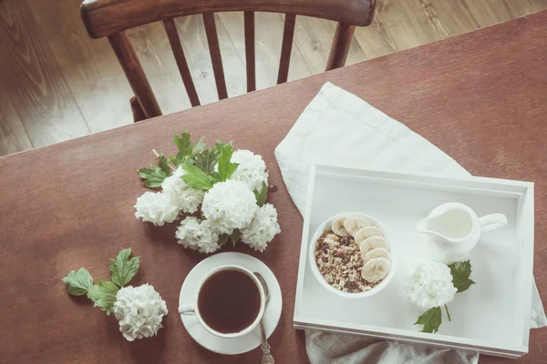 Zdravá snídaně. Šálek kávy, müsli a výzdoba s květinami. Rustikální interiér. Rustikální café. — Stock fotografie