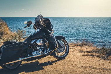 Siyah motosiklet güzel sahil ve mavi gökyüzü buradan. Kır, bozkır, yaz.