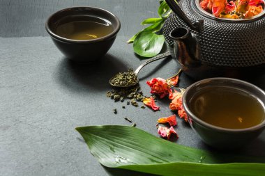 Yeşil çay siyah arduvaz arka plan üzerine gül çiçek ile. Kopya alanı ile yakın çekim.